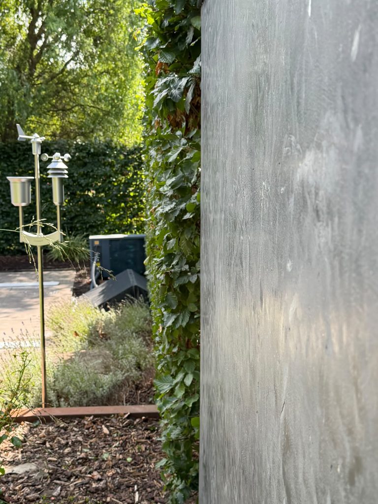 Begrünter Gartenbereich entlang einer modernen Gartenmauer